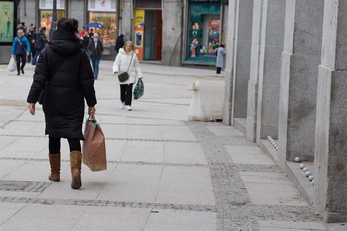Varias personas con bolsas en las inmediaciones de la remodelada y peatonalizada Puerta del Sol, a 4 de diciembre de 2022, en Madrid (España). Con motivo del puente de la Constitución la Puerta del Sol ha quedado despejada y accesible para facilitar la 