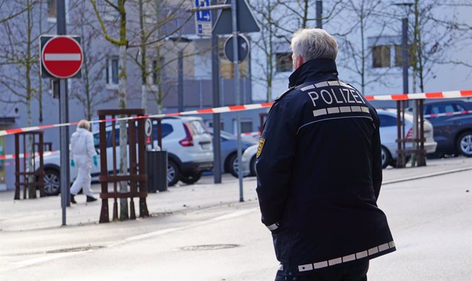 21 December 2022, Baden-Wuerttemberg, Ebingen: A police officer stands at a cordoned-off crime scene in Albstadt-Ebingen after a man had been shot and seriously injured in the street. According to police, he was taken to a hospital. A suspect was arrest