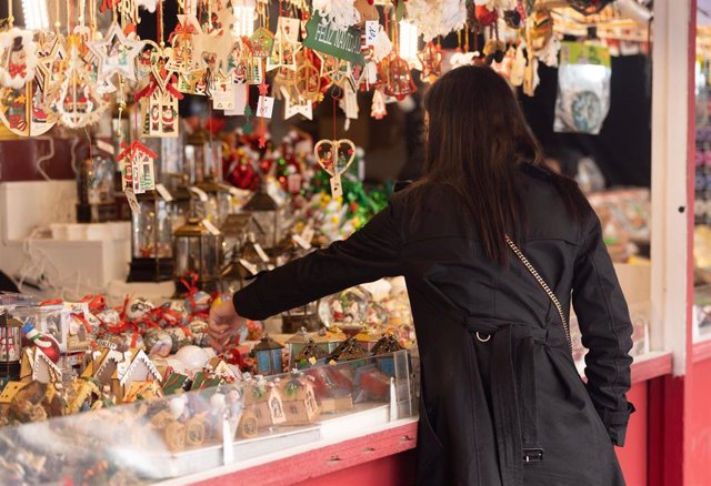 Una mujer frente a una de las casetas navideñas del Mercado de Navidad de la Plaza Mayor, a 29 de noviembre de 2022, en Madrid (España). Este mercadillo navideño, organizado por la Asociación del Mercado Tradicional Navideño de la Plaza Mayor, reúne a ven