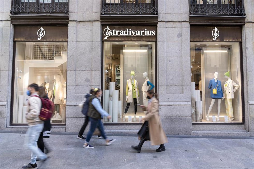 Archivo - Personas pasan por delante de un escaparate de una tienda  Stradivarius