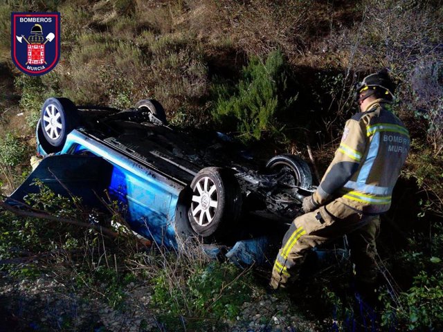 Un bombero junto al vehículo siniestrado