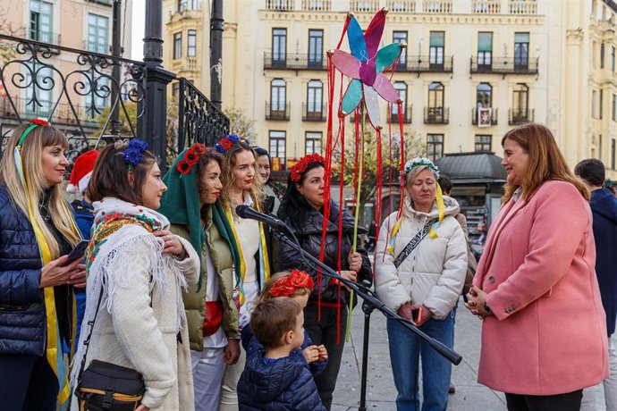 La alcaldesa de Segovia, Clara Martín (d), en representación de la ciudad, recibe la felicitación navideña y agradecimiento por parte de los ucranianos acogidos en Segovia, en la plaza Mayor.