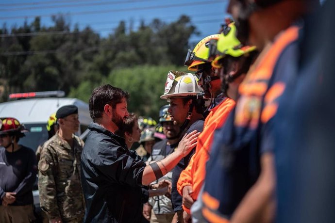El presidente de Chile, Gabriel Boric, saluda a los bomberos que operan en el incendio de Viña del Mar, en Valparaíso.