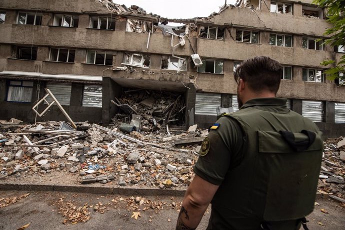 Archivo - Arxivo - Un soldat ucrans enfront d'un edifici bombardejat.