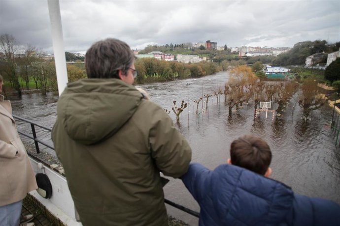 Un hombre y un niño observan la crecida del río Miño debido a las lluvias, en Lugo, a 25 de diciembre de 2022, en Lugo, Galicia.