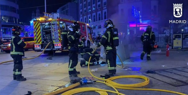 Bomberos trabajan en las labores para extinguir un incendio en Callao, Madrid