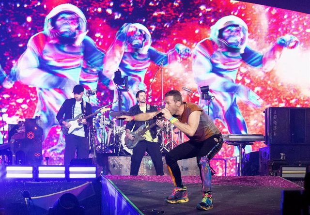 Archivo - 12 August 2022, United Kingdom, London: Chris Martin (R), lead singer of Coldplay, sings in front of Guy Berryman (L), the band's bassist, and Jonny Buckland, lead guitarist, on stage at Wembley Stadium in north London during the "Music of the S