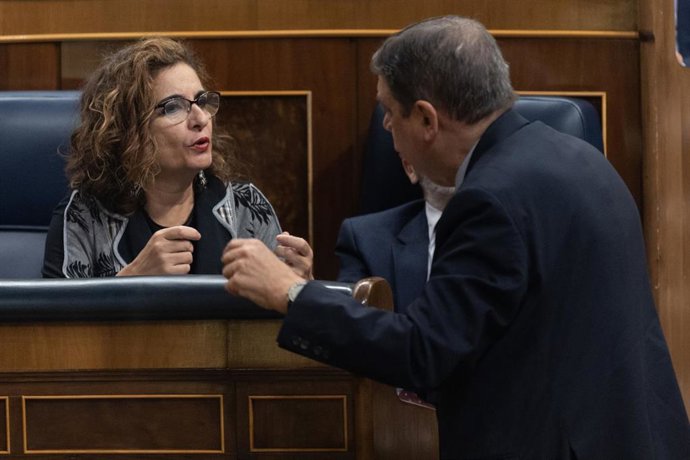 La ministra de Hacienda, María Jesús Montero y el ministro de Agricultura, Pesca y Alimentación, Luis Planas, conversan durante una sesión plenaria, en el Congreso de los Diputados