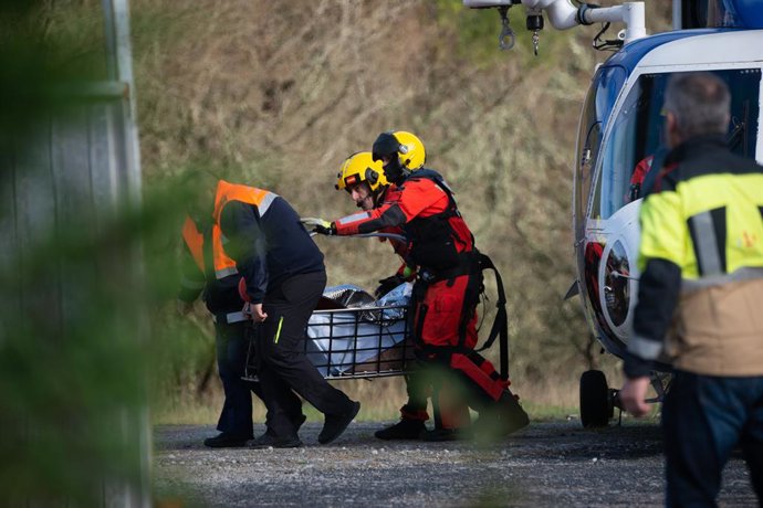 Efectivos de emergencias trasladan el último cadáver recuperado en la zona donde cayó el autobús al río Lérez.