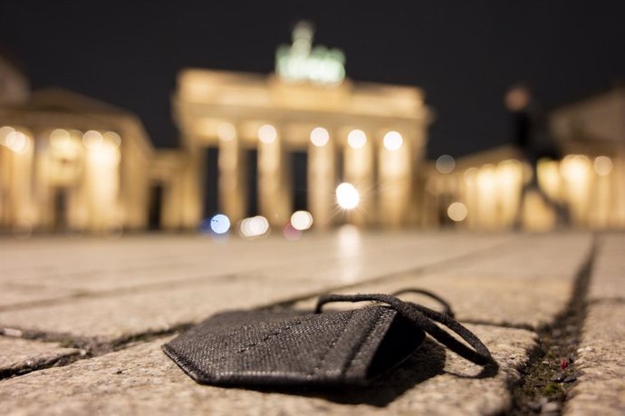 Archivo - FILED - 17 January 2022, Berlin: A black FFP2 mask lies on the ground in front of the Brandenburg Gate. Photo: Christophe Gateau/dpa
