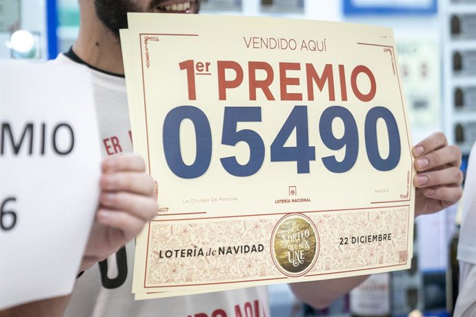 Un empleado de la administración situada en el intercambiador de Moncloa llamada 'La chulapa de Moncloa' celebra que han vendido parte del número 5490 correspondiente al 'Gordo' del Sorteo Extraordinario de la Lotería de Navidad, a 22 de diciembre de 20
