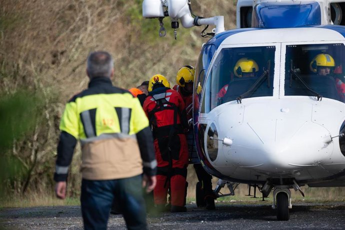 Efectivos de emergencias trasladan el último cadáver recuperado por el helicóptero 'Pesca I' en la zona donde cayó el autobús al río Lérez.
