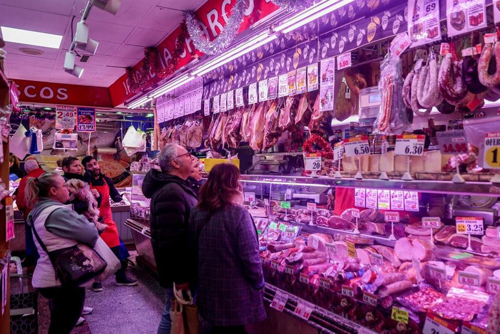 Varias personas esperan su turno en la charcutería para realizar sus últimas compras en la tienda de comestibles