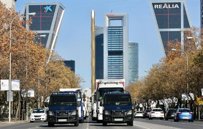 Archivo - Dos furgones de la Policía Nacional delante de los camiones que han participado en una marcha lenta en las inmediaciones de Plaza de Castilla con el fin de protestar por los problemas que sufre el sector, a 14 de diciembre de 2021, en Madrid (