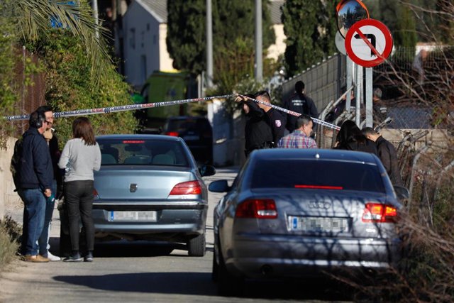 Un policía sostiene el precinto en las inmediaciones de la casa 