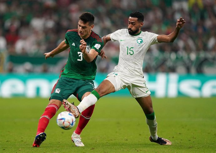 30 November 2022, Qatar, Lusail: Mexico's Cesar Montes (L) and Saudi Arabia's Ali Al-Hassan battle for the ball during the FIFA World Cup Qatar 2022 Group C soccer match between Saudi Arabia and Mexico at the Lusail Stadium. Photo: Mike Egerton/PA Wire/