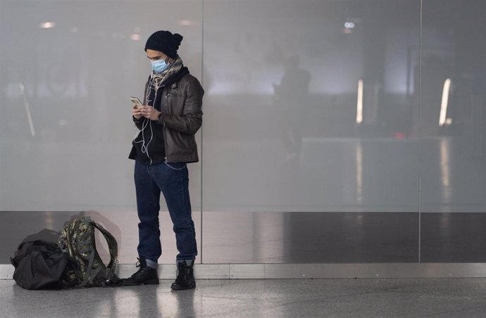 Un viajeros consulta su móvil en la estación de tren de Atocha. 