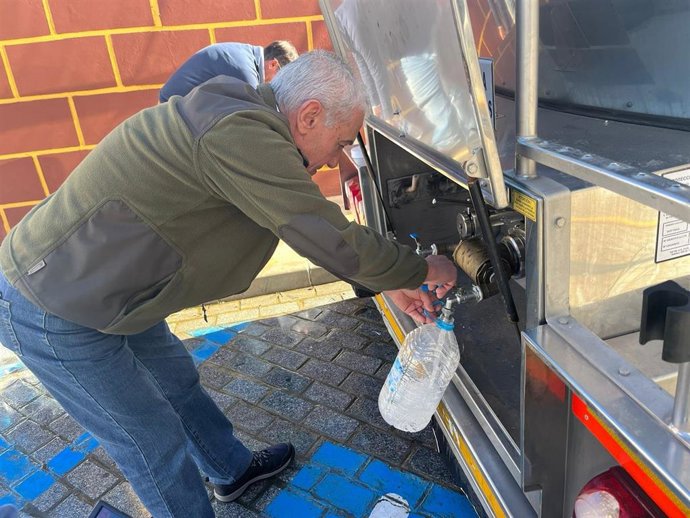 Vecino de El Real de la Jara cogiendo agua del camión cisterna que se ha instalado en el municipio.