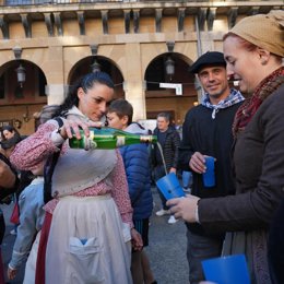 Una mujer escancia sidra en la feria de Santo Tomás, a 21 de diciembre de 2022, en San Sebastián