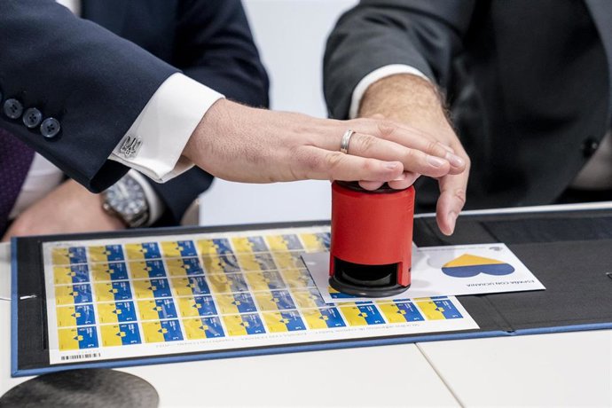 Archivo - Varias manos pulsan el sello España con Ucrania