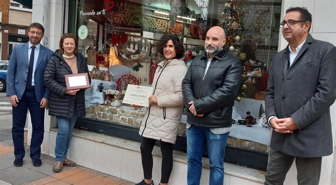 E consejero de Industria, Empleo y Promoción Económica, Enrique Fernández (izda), durante la entrega de premios del 40 concurso de escaparates navideños de Gijón