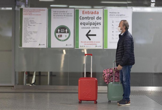 Un viajero espera en la entrada de control de equipajes en la estación de tren de Atocha, a 23 de diciembre de 2022, en Madrid (España)