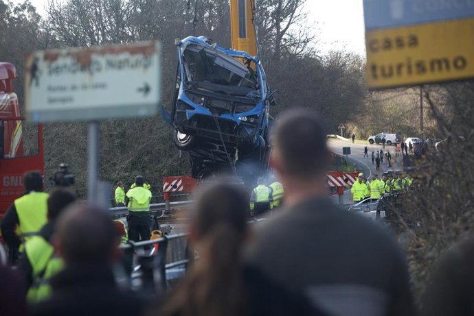 Una grúa coloca el autobús accidentado sobre el puente para sacarlo del cauce del río Lérez.