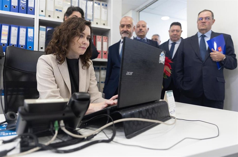 La presidenta de la Comunidad de Madrid, Isabel Díaz Ayuso (1i), y el secretario de la Asociación Gremial del Auto-Taxi de Madrid, Miguel Ángel García (3d), en una visita a la sede de la Asociación Gremial del Auto-Taxi de Madrid, a 29 de diciembre de 2