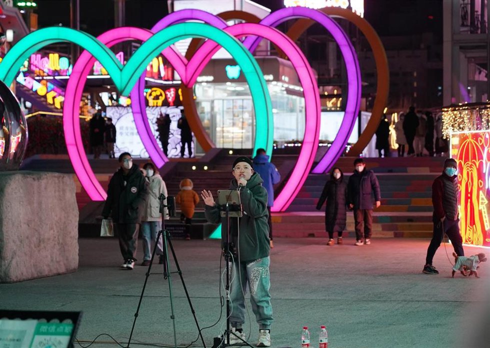 Una artista canta en una zona de negocios de Pekín, capital de China