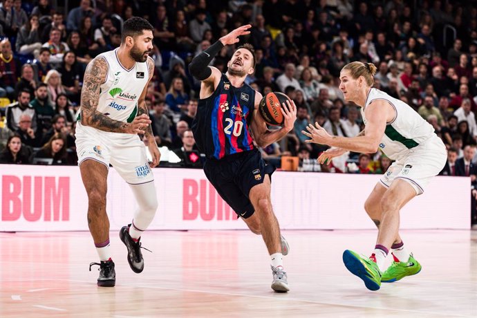 Nico Laprovittola of FC Barcelona in action against Augusto Lima of Unicaja  during the ACB Liga Endesa match between FC Barcelona and Unicaja  at Palau Blaugrana on December 18, 2022 in Barcelona, Spain.