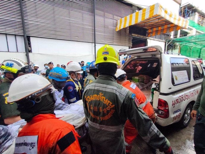 Operarios meten en un vehículo el cuerpo de uno de los fallecidos en el incendio