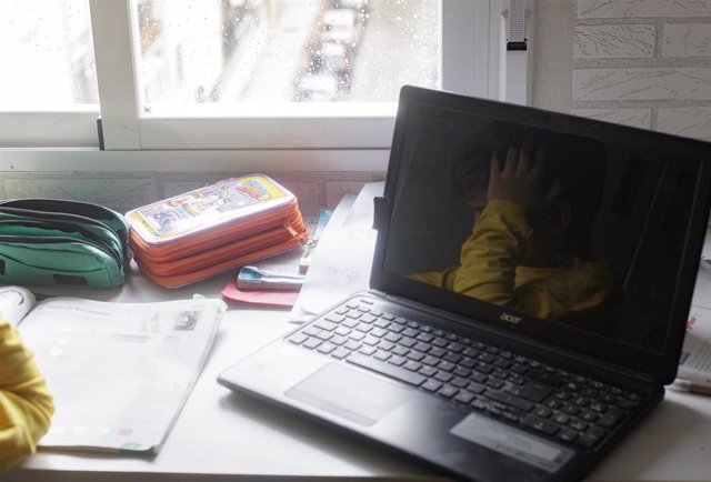 Archivo - Reflejo en un ordenador portátil de un niño estudiando 