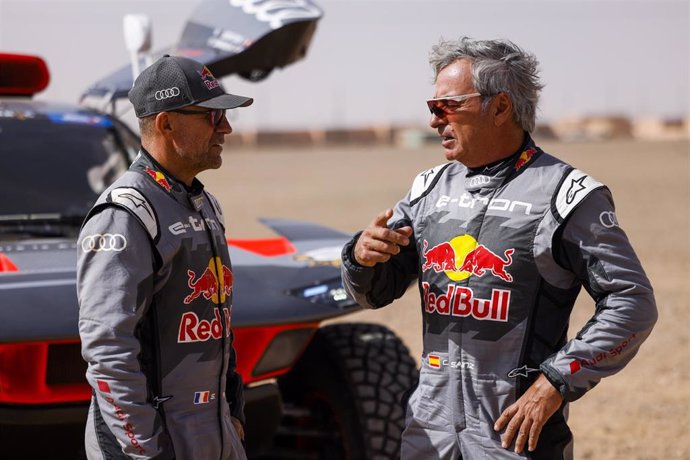 Archivo - Carlos Sainz habla con Stephane Peterhansel durante el Rally de Marruecos