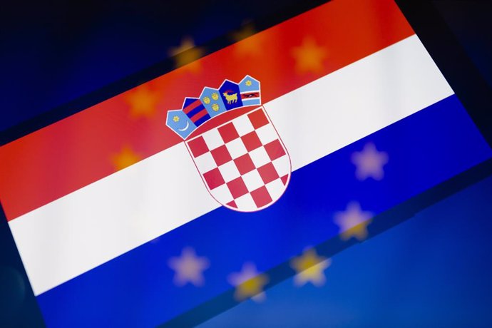 08 December 2022, Paraguay, Asuncion: A general view of the Croatian flag displayed on a smartphone backdropped by a cropped flag of the European Union. Croatia has received the go-ahead to join Europe's passport-free Schengen area in January 1, 2023, C