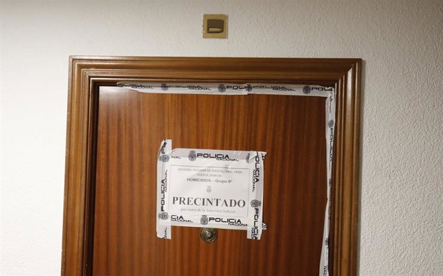 Archivo - La puerta de una vivienda precintada por la Policía Nacional, donde un hombre mató a su pareja y a su hija, este año 2022, en Móstoles.