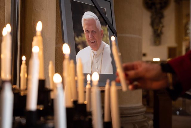Velas junto a una fotografía de Benedicto XVI en la catedral de Paderborn, en Alemania.