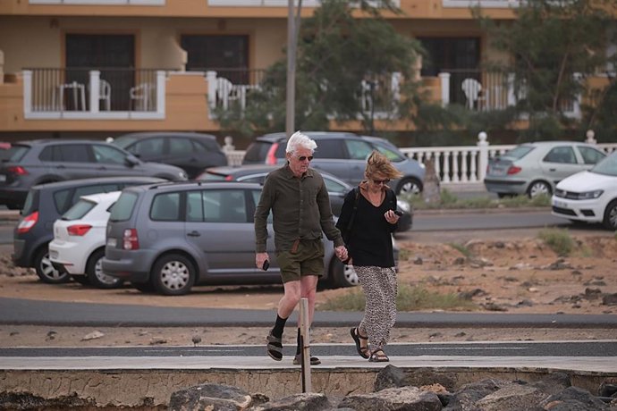 Dos personas caminan entre fuertes rachas de viento