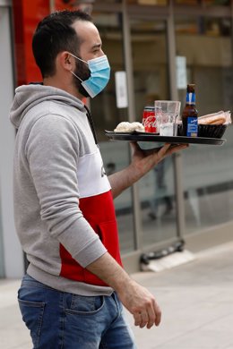Archivo - Un camarero atiende la terraza de un bar.