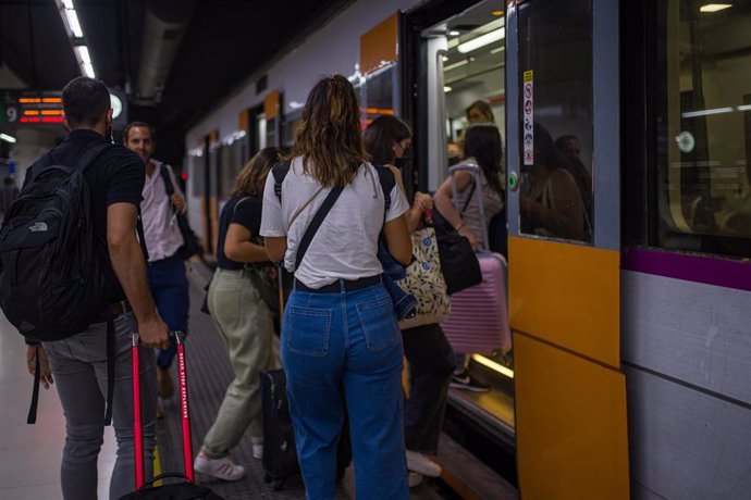 Archivo - Viajeros suben a un tren en uno de los andenes de la estación de Sants, a 9 de septiembre de 2022, en Barcelona, Catalunya (España).