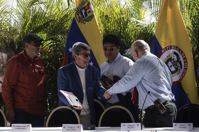 12 December 2022, Venezuela, Caracas: Pablo Beltran (2nd L), representative of the National Liberation Army (ELN), shakes hands with Colombian government representative Otty Patino (R) after a press conference following peace talks between the ELN and t