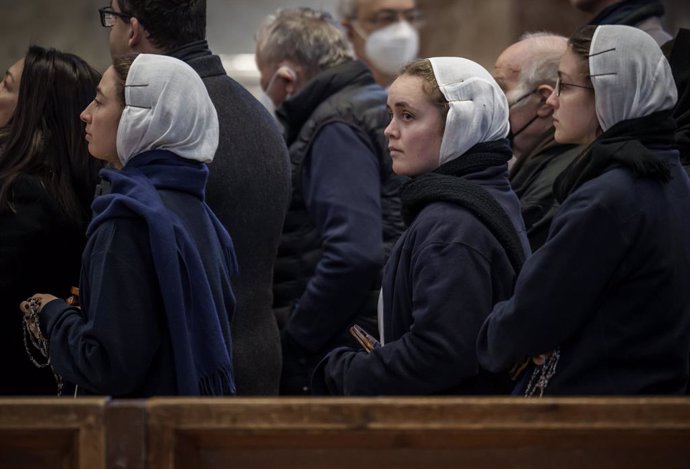 02 January 2023, Vatican, Vatican City: Visitors wait around the body of the late Pope Benedict XVI, who's publicly laid out in St. Peter's Basilica. Photo: Michael Kappeler/dpa - ATTENTION: graphic content