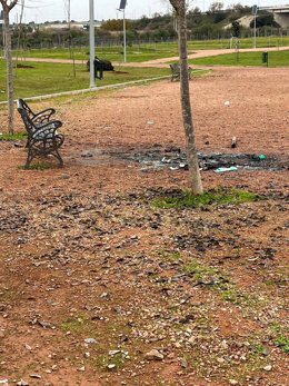 Restos de fogatas en el Parque de Levante para las que se han empleado árboles y estructuras de madera recién instalados.
