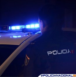 Un agente de Policía Nacional junto a su vehículo