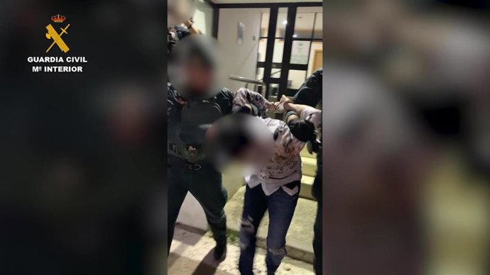 Agentes conduciendo al detenido