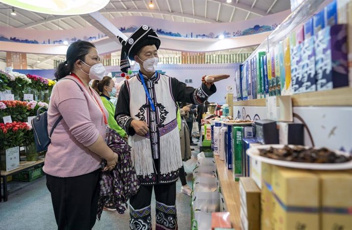 Archivo - Personas con mascarilla en una feria de Kunming, en Yunnan, China