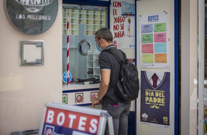 Archivo - Una persona compra un boleto de Euromillones en una Administración de Loterías, en una foto de archivo.