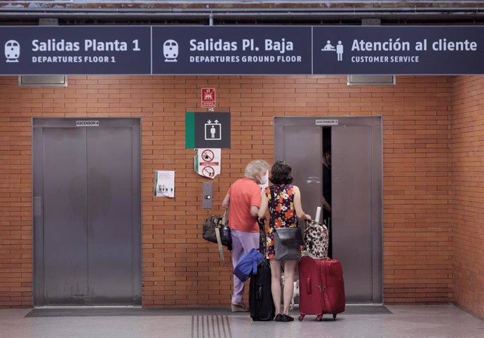 Archivo - Dos mujeres esperan a un ascensor, en la estación de Madrid - Puerta de Atocha