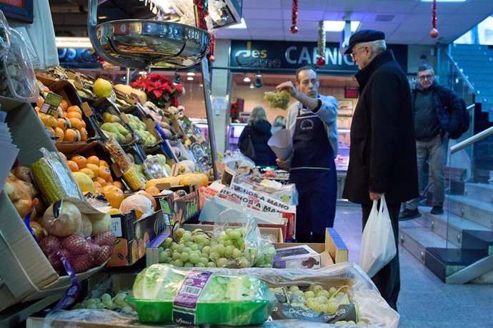 Varias personas en una frutería en el mercado de Prosperidad, 