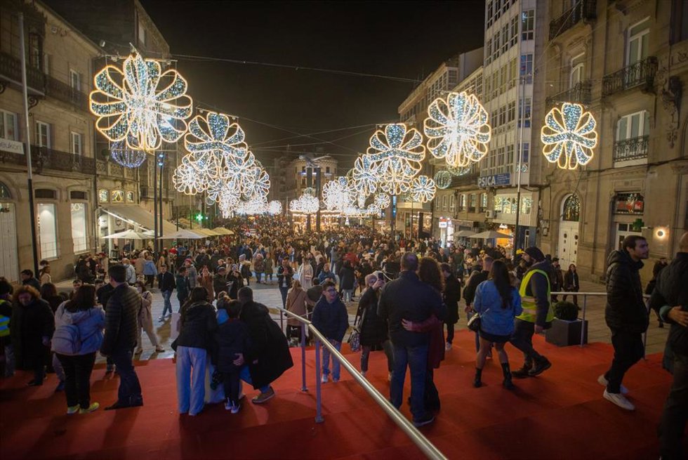 Varias personas pasean por el centro de la ciudad de Vigo para disfrutar de la iluminación navideña.