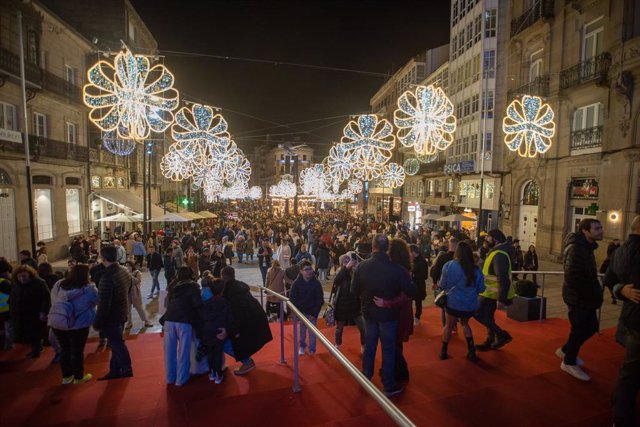 Varias personas pasean por el centro de la ciudad de Vigo para disfrutar de la iluminación navideña.